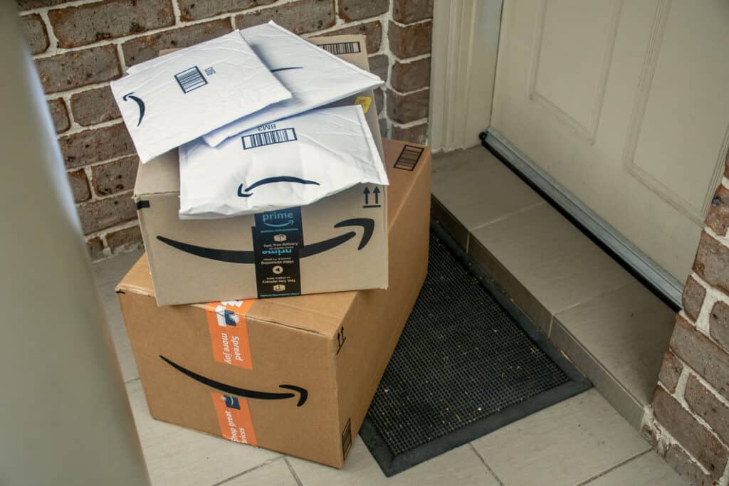 Amazon prime boxes and envelopes delivered to a front door of residential building