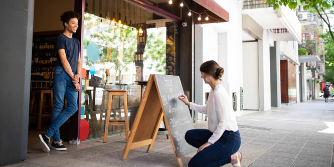 employees-chalking-sandwich-board-indie-store