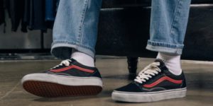 close up of a pair of feet wearing grey and orange sneakers