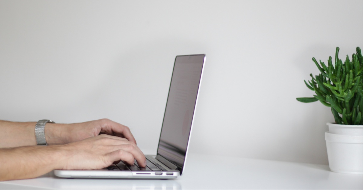 Hands typing on a computer.