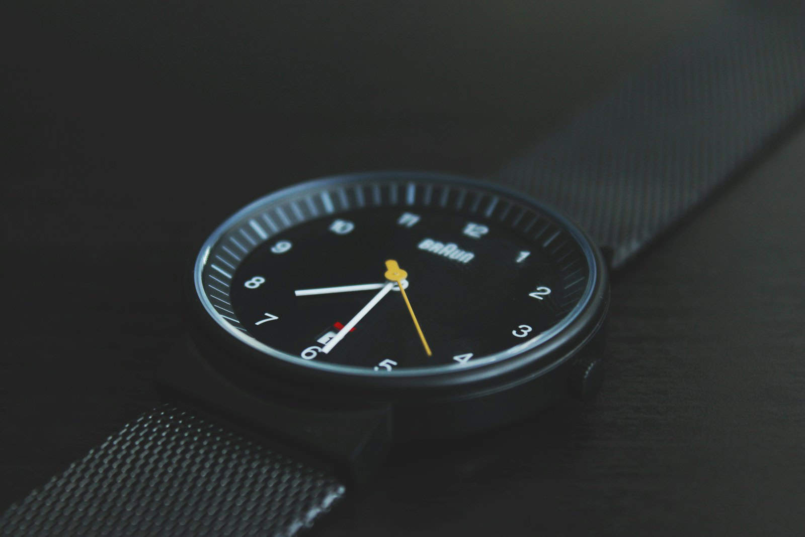 round black Braun analog watch with black band at 7:30