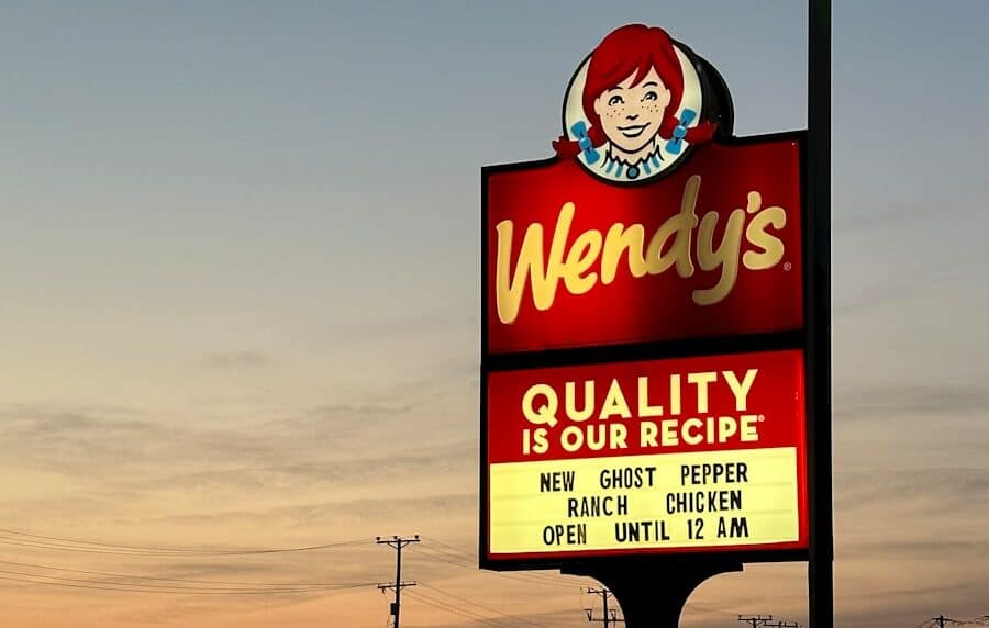 a sign for wendy's restaurant in a parking lot